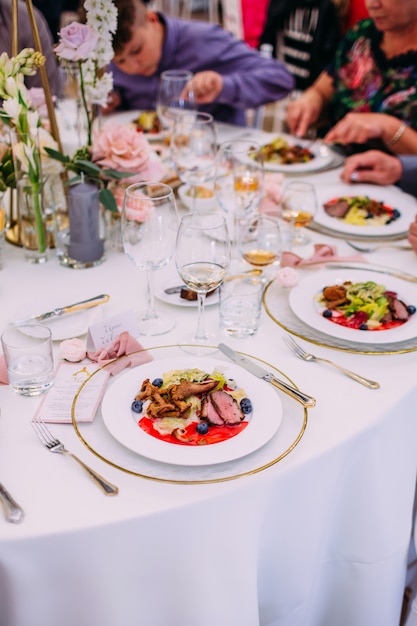 Meat dish with vegetables for catering. Lots of plates.