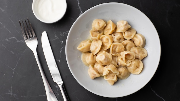 Meat dumplings homemade russian pelmeni in bowl isolated on dark background with clipping path