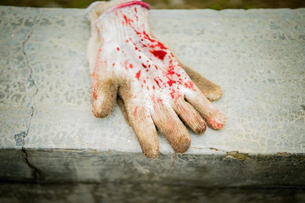 Photo meat gloves with blood stains on the concrete