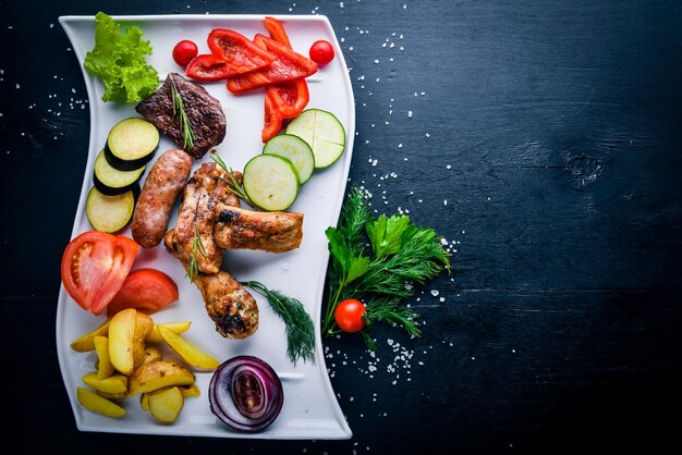 Meat grilled assorted and vegetable sliced On a wooden background Top view Free space for your text