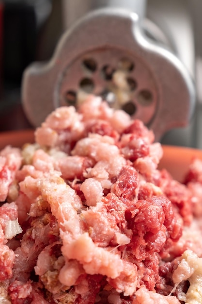 Meat grinder and minced meat falling selective focus vertical photo selective focus