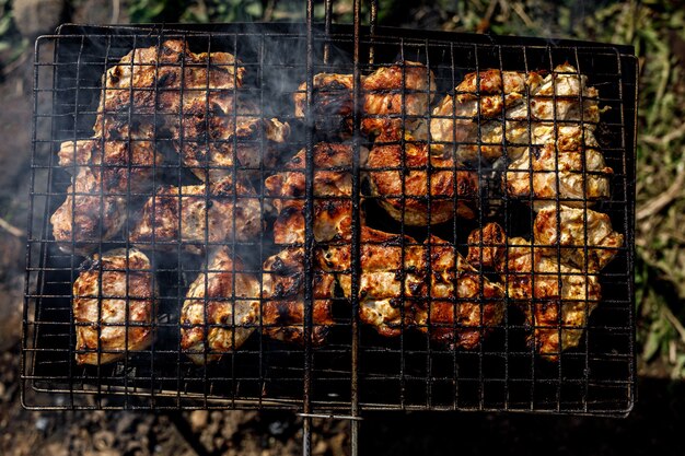 Мясо обжаривается на мангале. Решётка с запечённой свининой