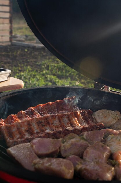 Photo the meat is grilled on a portable charcoal grill