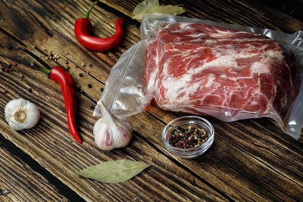 The meat is Packed in a vacuum bag on a wooden background