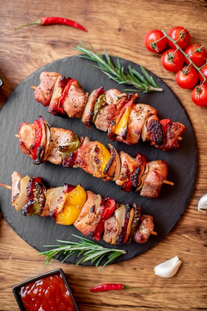 Meat kebabs with grilled vegetables on a rustic background