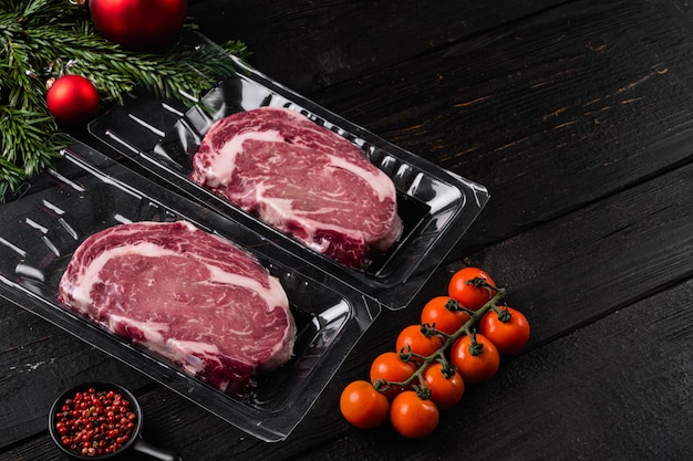 Meat in a package on black wooden table background with copy space for text