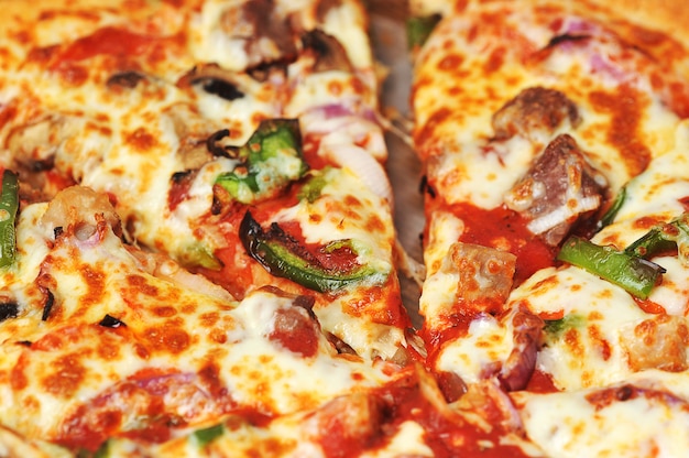 Meat and pepper pizza lies on cardboard