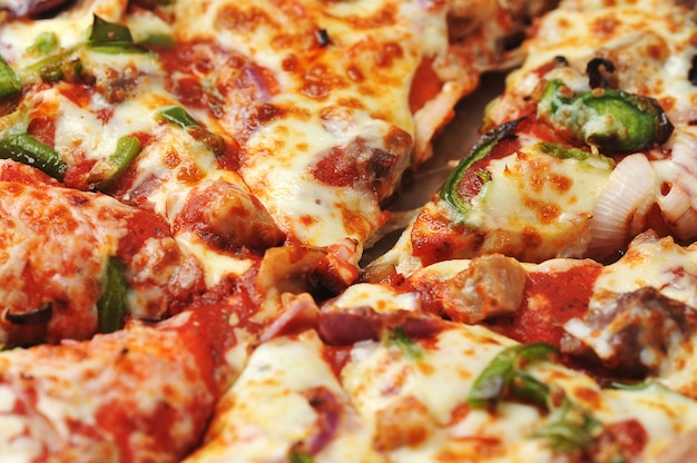 Пицца с мясом и перцем лежит на картоне