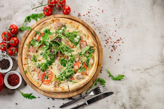 Meat pizza with ham and cheese on the white concrete background