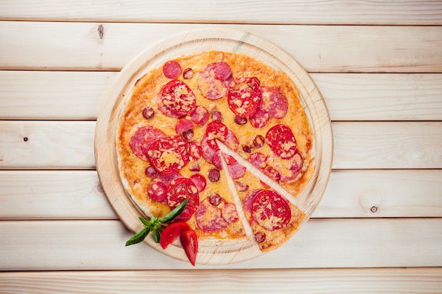 Meat Pizza with tomatoes on the wooden table