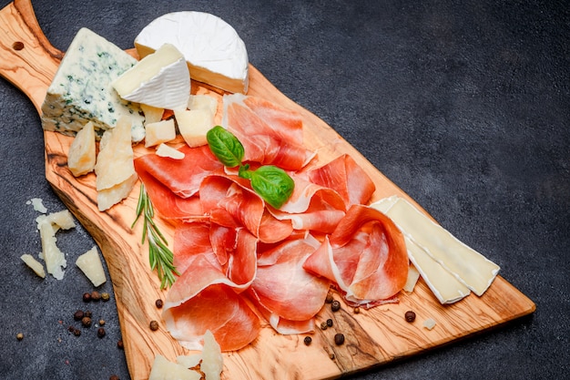 Photo meat plate of italian prosciutto crudo or spanish jamon and cheese