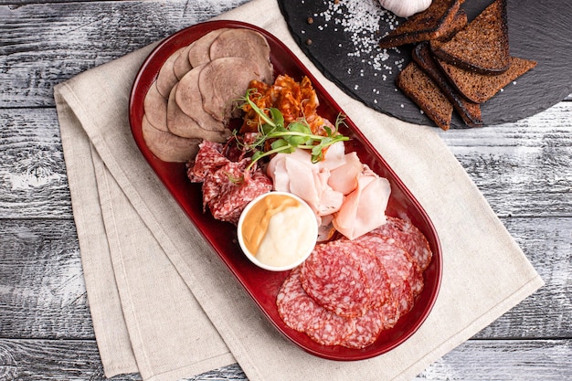 Meat plate meat appetizer on a wooden white background