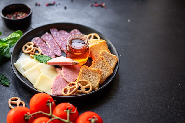 meat platter ham slices, cheese plate and crackers sausage salami food