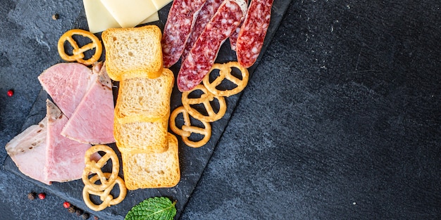 Meat platter, ham slices, cheese plate and crackers sausage smoked or dry-cured salami