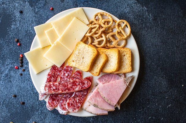 Meat platter, ham slices, cheese plate and crackers sausage smoked or dry-cured salami