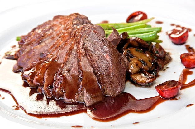 meat in plum sauce slices of meat dipped in sauce with cooked vegetables food gastronomy