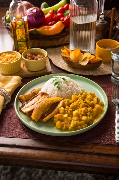 Meat and potatoes stew with fried bananas Peru peruvian food serving plate buffet wooden table