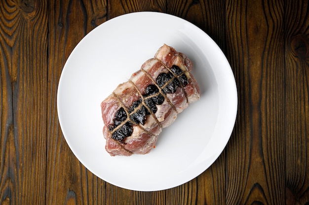 meat products on a white plate on a wooden table