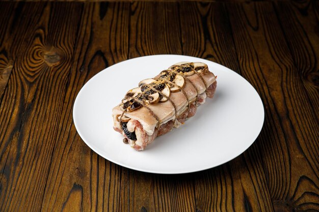 meat products on a white plate on a wooden table