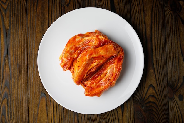 meat products on a white plate on a wooden table