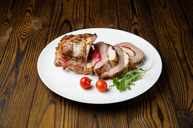 Photo meat products on a white plate on a wooden table