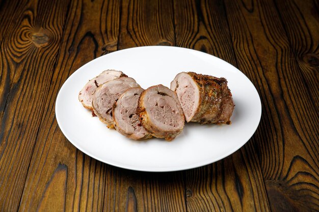 meat products on a white plate on a wooden table