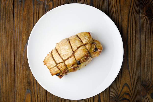 meat products on a white plate on a wooden table