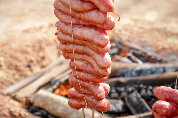 Meat roast and cut on the table and campfire with gaucho style firewood