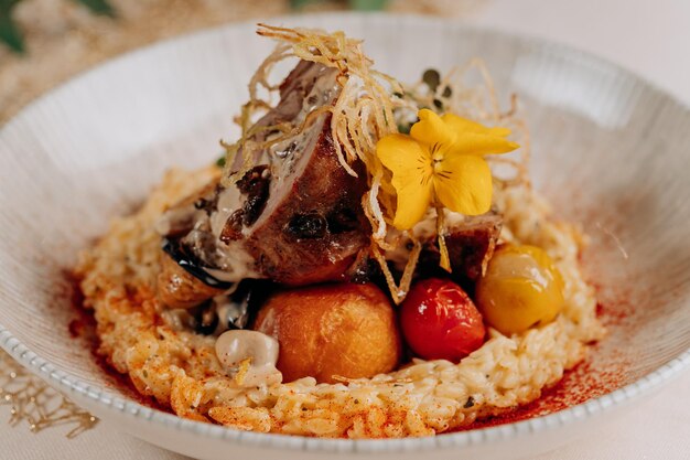 Meat roll with prunes is served on a pillow of vegetables and rice in restaurant