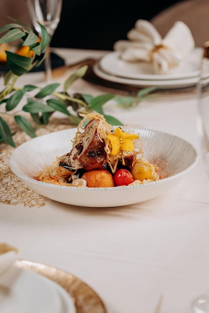 Meat roll with prunes is served on a pillow of vegetables and rice in restaurant