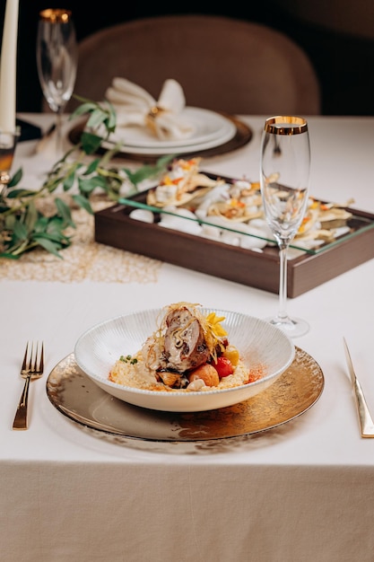 Meat roll with prunes is served on a pillow of vegetables and rice in restaurant