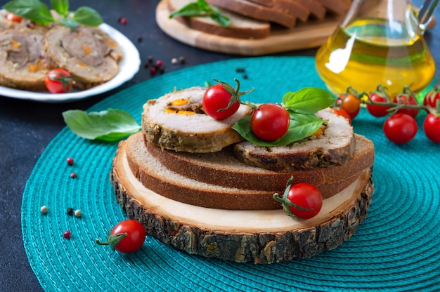 Meat rolls on rye bread with cherry tomatoes and basil