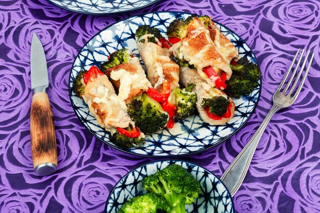 Foto rotoli di carne con broccoli e pepe su un piatto