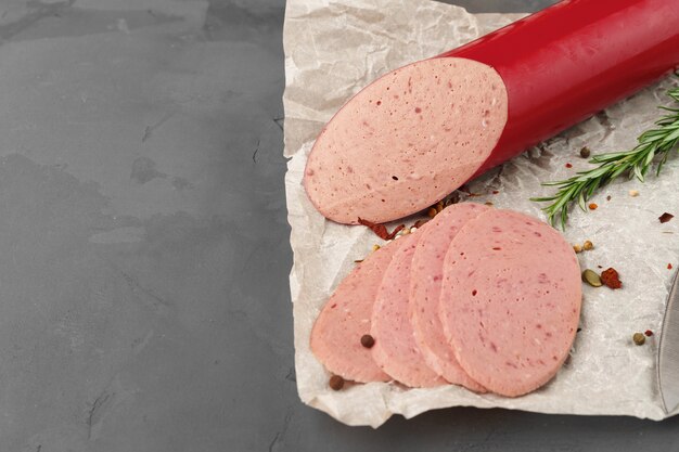 Meat sausage on parchment on gray