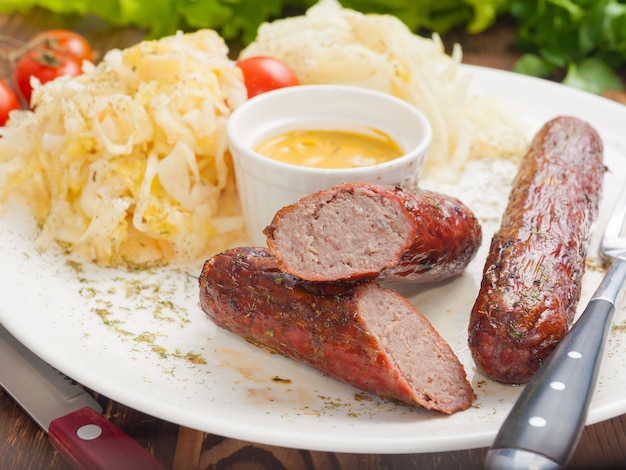 Meat sausages with mustard sauce and cabbage