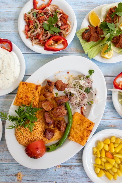 Meat shish kebab in a plate with appetizers top wiev