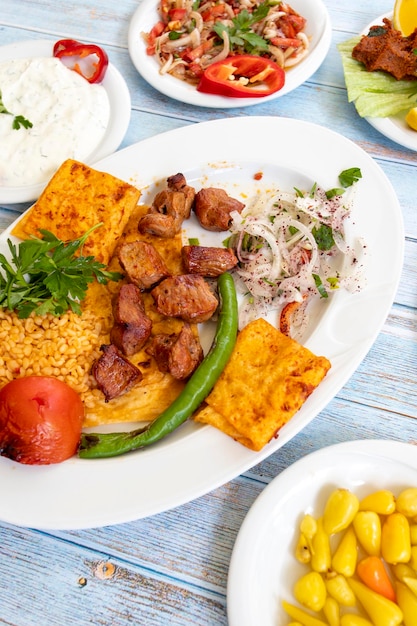 Meat shish kebab in a plate with appetizers