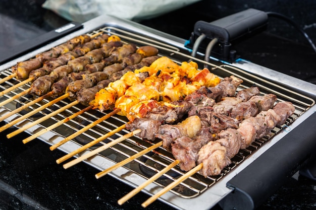 Meat skewer or brazilian traditional espetinho de carne on a eletric grill