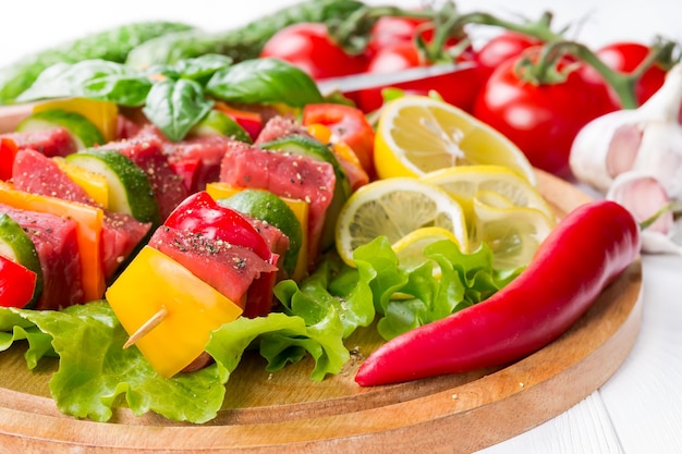 Meat on skewers with vegetables on salad leaves