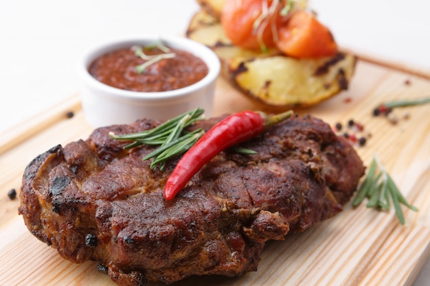 Bistecca di carne con salsa su una tavola di legno