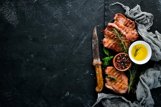 로즈마리와 고기 스테이크 그릴 바베큐 검은 돌 배경 상위 뷰 무료 복사 공간