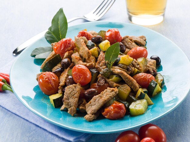 Meat stew with tomatoes zucchinis and olives