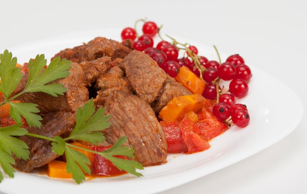 Meat stew with vegetables and red currants