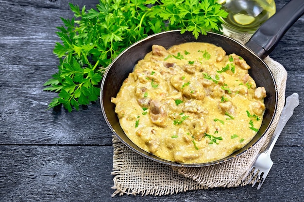 Meat stewed with cream in pan on black board