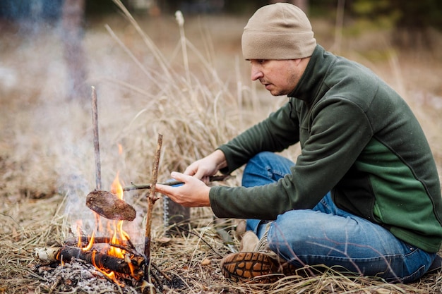 Meat on the stick grilled in the fire bushcraft concept