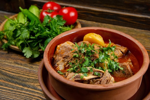 Meat with potato stew served on plate on dark background