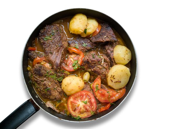 Meat with potatoes in iron pan