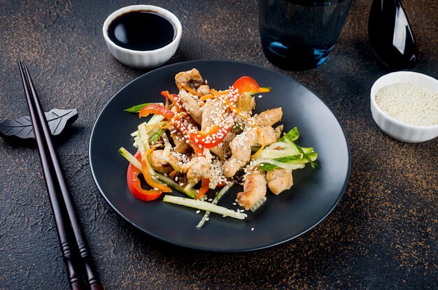 Meat with vegetables wok in thai in a black bowl