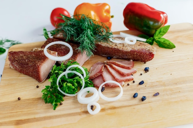 Meat on a wooden board with vegetables