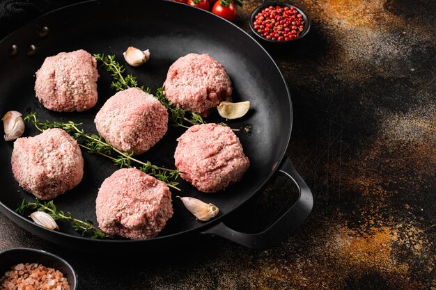 Meatball patties from minced meat on old dark rustic table background with copy space for text